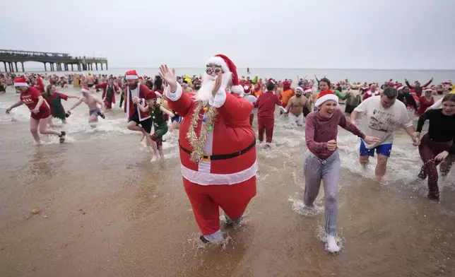 Swimmers take part in the Macmillan Boscombe White Christmas Dip, in aid of Macmillan Caring Locally, at Boscombe Pier in Bournemouth, England, Wednesday Dec. 25, 2024. (Andrew Matthews/PA via AP)