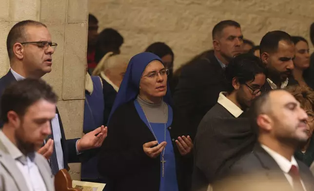 Christians attend the Christmas midnight Mass at the Church of the Nativity traditionally believed to be the birthplace of Jesus, in the West Bank city of Bethlehem, Tuesday Dec. 24, 2024. (Alaa Badarneh/Pool via EPA)