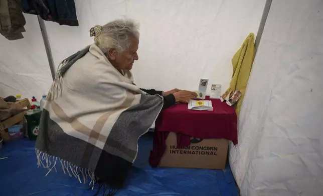 Amal Amouri sets up a little altar at the tent she and her husband Tony Al-Masri, both Christians, share at the Muwassi tent camp near Khan Younis, Gaza Strip on Christmas Day Wednesday Dec. 25, 2024.(AP Photo/Abdel Kareem Hana)