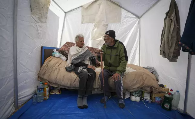 Elderly Christian married couple Amal Amouri and her husband Tony Al-Masri sit at their tent at the Muwassi tent camp near Khan Younis, Gaza Strip on Christmas Day Wednesday Dec. 25, 2024. (AP Photo/Abdel Kareem Hana)