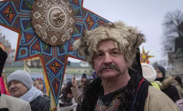 A man wearing a national costume celebrates Christmas near St. Michael Monastery in a city centre in Kyiv, Ukraine, Wednesday, Dec. 25, 2024. (AP Photo/Efrem Lukatsky)