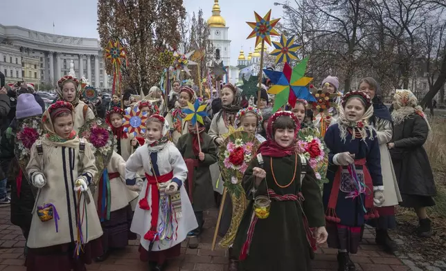 People wearing national suits sing carols as they celebrate Christmas near St. Michael Monastery in a city centre in Kyiv, Ukraine, Wednesday, Dec. 25, 2024. (AP Photo/Efrem Lukatsky)