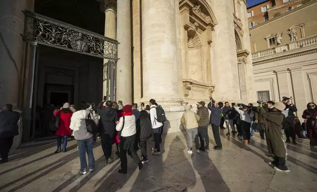 Faithful arrive to walk through the Holy Door of St.Peter's Basilica at the Vatican, Wednesday, Dec. 25, 2024, after it was opened by Pope Francis on Christmas Eve marking the start of the Catholic 2025 Jubilee. (AP Photo/Andrew Medichini)