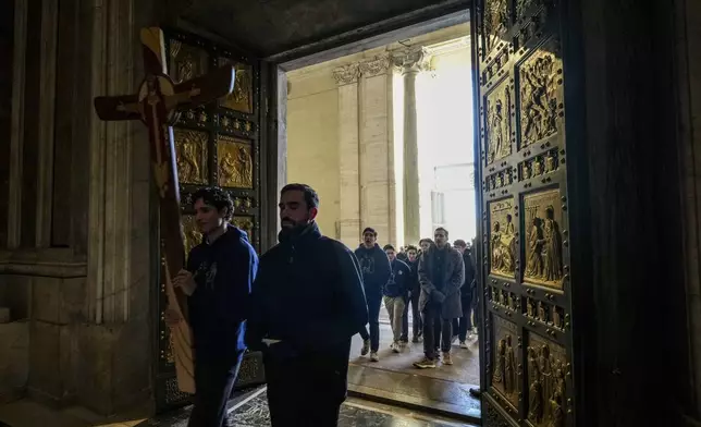 Faithful walk through the Holy Door of St.Peter's Basilica at the Vatican, Wednesday, Dec. 25, 2024, after it was opened by Pope Francis on Christmas Eve marking the start of the Catholic 2025 Jubilee. (AP Photo/Andrew Medichini)