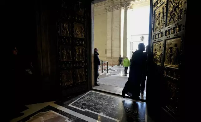 Faithful walk through the Holy Door of St. Peter's Basilica at the Vatican, Wednesday, Dec. 25, 2024, after it was opened by Pope Francis on Christmas Eve marking the start of the Catholic 2025 Jubilee. (AP Photo/Andrew Medichini)