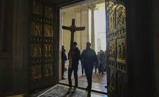 Faithful walk through the Holy Door of St.Peter's Basilica at the Vatican, Wednesday, Dec. 25, 2024, after it was opened by Pope Francis on Christmas Eve marking the start of the Catholic 2025 Jubilee. (AP Photo/Andrew Medichini)