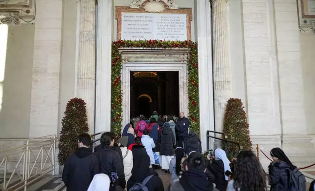 Faithful walk through the Holy Door of St.Peter's Basilica at the Vatican, Wednesday, Dec. 25, 2024, after it was opened by Pope Francis on Christmas Eve marking the start of the Catholic 2025 Jubilee. (AP Photo/Andrew Medichini)