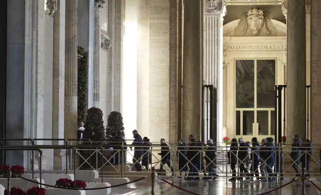 Faithful arrive to walk through the Holy Door of St.Peter's Basilica at the Vatican, Wednesday, Dec. 25, 2024, after it was opened by Pope Francis on Christmas Eve marking the start of the Catholic 2025 Jubilee. (AP Photo/Andrew Medichini)