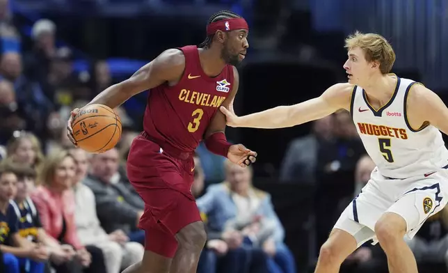 Cleveland Cavaliers guard Caris LeVert, left, looks to drive to the basket as Denver Nuggets forward Hunter Tyson, right, defends in the first half of an NBA basketball game Friday, Dec. 27, 2024, in Denver. (AP Photo/David Zalubowski)