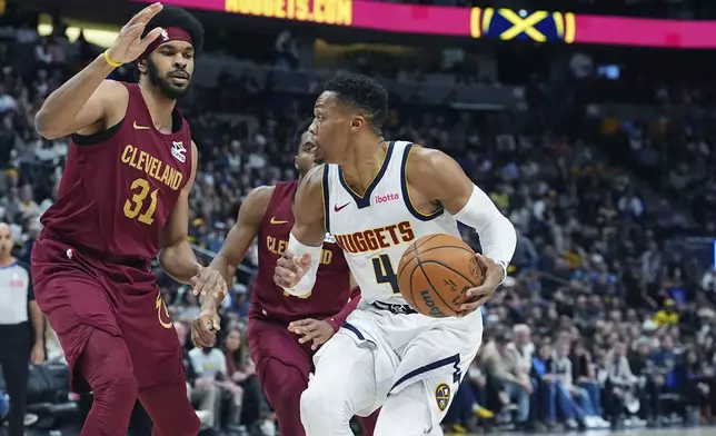 Denver Nuggets guard Russell Westbrook, right, drives to the basket as Cleveland Cavaliers center Jarrett Allen defends in the first half of an NBA basketball game Friday, Dec. 27, 2024, in Denver. (AP Photo/David Zalubowski)