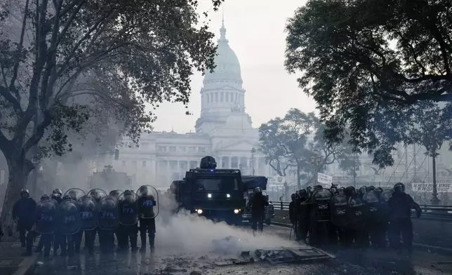 FILE - Police clear the streets during clashes with anti-government protesters outside Congress, where lawmakers debate a reform bill promoted by President Javier Milei in Buenos Aires, Argentina, June 12, 2024. (AP Photo/Rodrigo Abd, File)