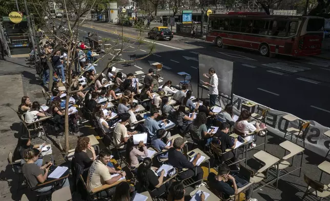 FILE - Economics students hold class outside Argentina's University of Buenos Aires to protest President Javier Milei's veto of higher funding for public universities, in Buenos Aires, Oct. 16, 2024. (AP Photo/Victor R. Caivano, File)