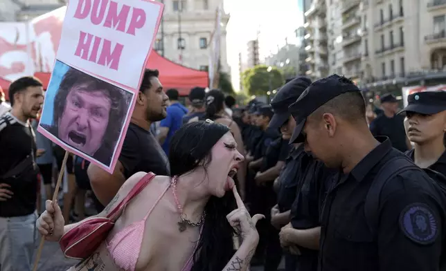 FILE - An anti-government protester taunts police guarding Congress where lawmakers are debating a bill promoted by Argentine President Javier Milei, in Buenos Aires, Argentina, Feb. 1, 2024. The bill includes a broad range of economic, administrative, criminal and environmental reforms. (AP Photo/Rodrigo Abd, File)