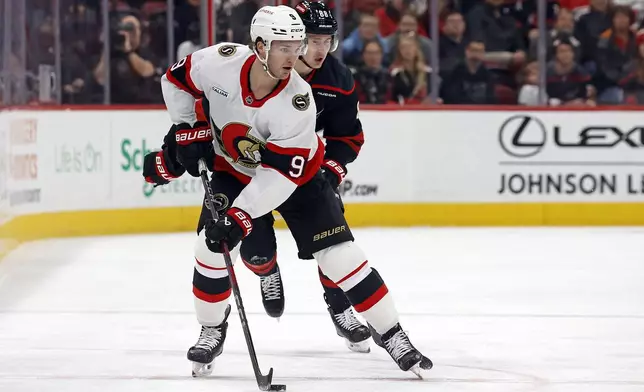 Ottawa Senators' Josh Norris (9) protects the puck in front of Carolina Hurricanes' Martin Necas (88) during the first period of an NHL hockey game in Raleigh, N.C., Friday, Dec. 13, 2024. (AP Photo/Karl B DeBlaker)