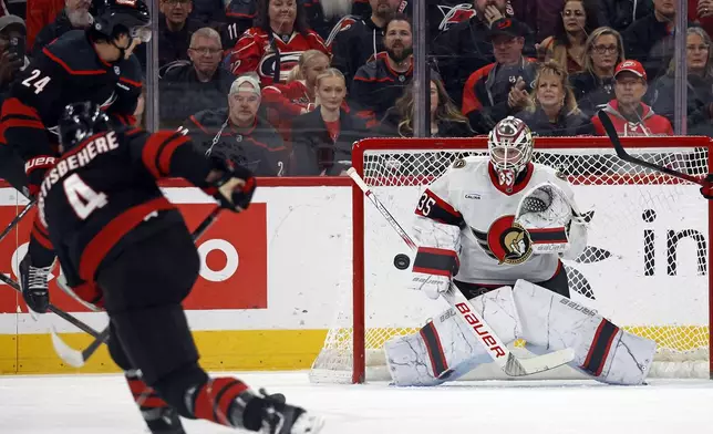 Carolina Hurricanes' Shayne Gostisbehere (4) shoots the puck at Ottawa Senators goaltender Linus Ullmark (35) during the first period of an NHL hockey game in Raleigh, N.C., Friday, Dec. 13, 2024. (AP Photo/Karl B DeBlaker)