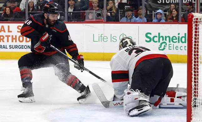 Ottawa Senators goaltender Linus Ullmark (35) covers the puck in front of a charging Carolina Hurricanes' Jordan Martinook (48) during the second period of an NHL hockey game in Raleigh, N.C., Friday, Dec. 13, 2024. (AP Photo/Karl B DeBlaker)