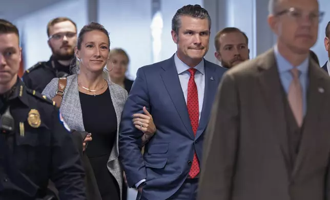 Pete Hegseth, center right, President-elect Donald Trump's nominee to be defense secretary, joined by his wife Jennifer Rauchet, arrives to meet with Sen. Mike Rounds, R-S.D., a member of the Senate Armed Services Committee, at the Capitol in Washington, Thursday, Dec. 5, 2024. (AP Photo/J. Scott Applewhite)