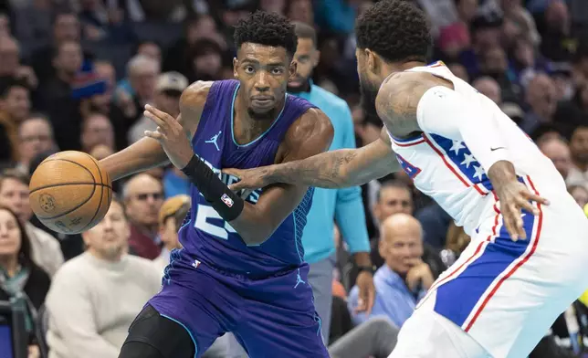 Charlotte Hornets forward Brandon Miller, left, looks to drive to the basket against Philadelphia 76ers forward Paul George during the first half of an NBA Cup basketball game in Charlotte, N.C., Tuesday, Dec. 3, 2024. (AP Photo/Nell Redmond)