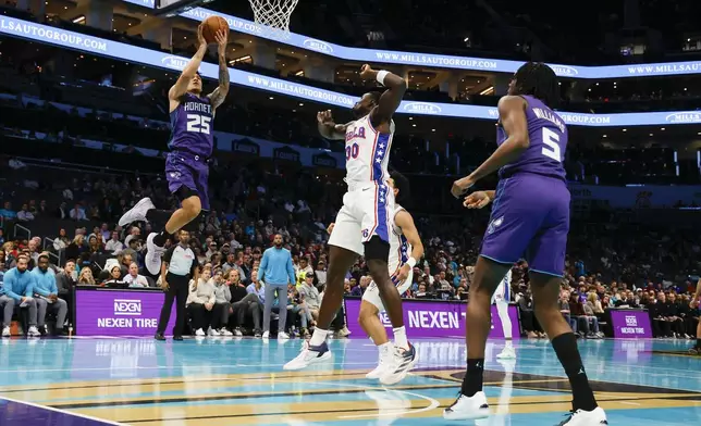 Charlotte Hornets guard KJ Simpson (25) shoots as Philadelphia 76ers center Adem Bona (30) and Charlotte Hornets center Mark Williams (5) look on during the first half of an NBA Cup basketball game in Charlotte, N.C., Tuesday, Dec. 3, 2024. (AP Photo/Nell Redmond)