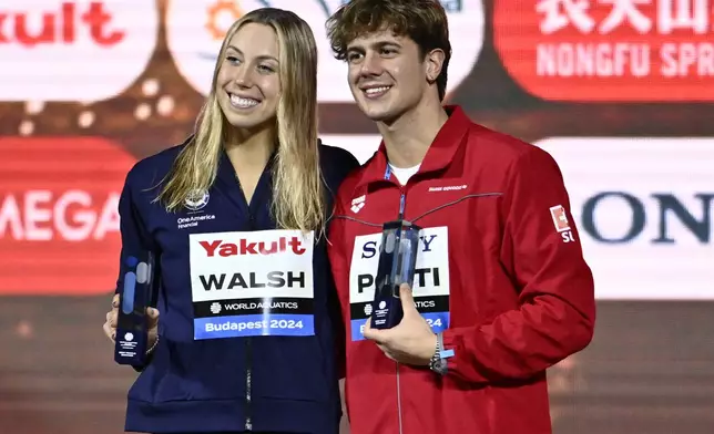 Gretchen Walsh of the United States and Switzerland's Hoe Ponti hold trophies for the best swimmers of the championship at the World Short Course Swimming Championships in Budapest, Hungary, on Sunday, Dec. 15, 2024. (AP Photo/Denes Erdos)