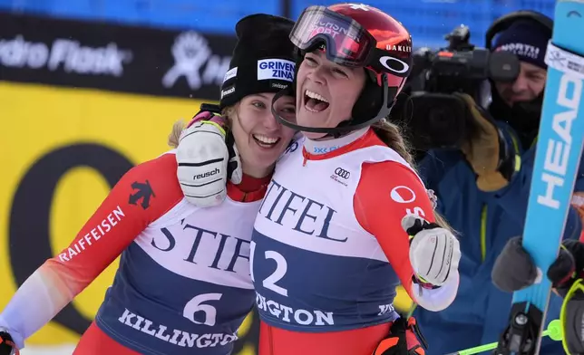 Camille Rast, of Switzerland, left, is hugged by teammate Melanie Meillard after winning a women's World Cup slalom skiing race, Sunday, Dec. 1, 2024, in Killington, Vt. (AP Photo/Robert F. Bukaty)