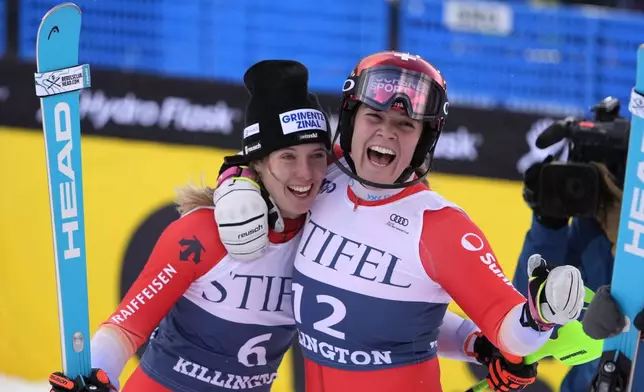 Camille Rast, of Switzerland, left, is hugged by teammate Melanie Meillard after winning a women's World Cup slalom skiing race, Sunday, Dec. 1, 2024, in Killington, Vt. (AP Photo/Robert F. Bukaty)