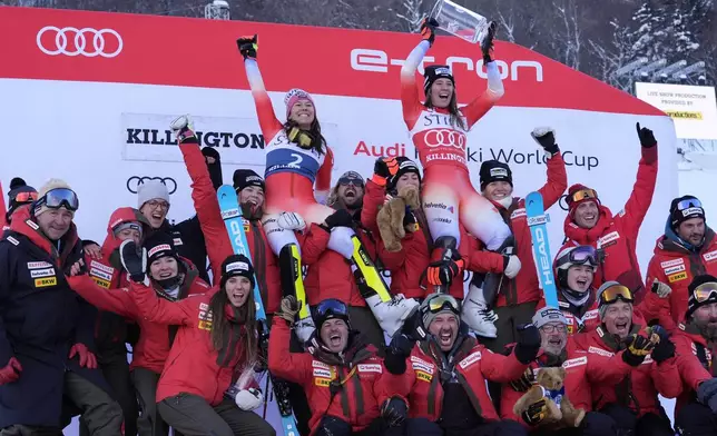 Camille Rast, of Switzerland, top right, celebrates her victory in a women's World Cup slalom skiing race, with second place finisher Wendy Holdener, top left, along with teammates and coaches, Sunday, Dec. 1, 2024, in Killington, Vt. (AP Photo/Robert F. Bukaty)