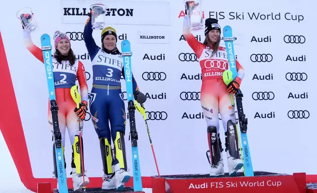 Camille Rast, of Switzerland, right, celebrates her victory in a women's World Cup slalom skiing race, with second place finishers Wendy Holdener, of Switzerland, left, and Anna Swenn Larsson, of Sweden, Sunday, Dec. 1, 2024, in Killington, Vt. (AP Photo/Robert F. Bukaty)