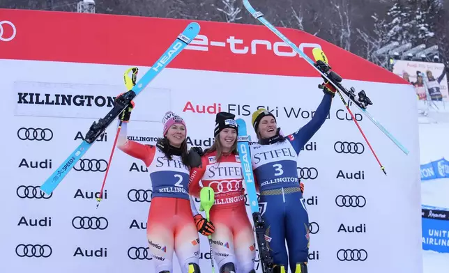 Camille Rast, of Switzerland, center, celebrates her victory in a women's World Cup slalom skiing race, with second place finishers Wendy Holdener, of Switzerland, left, and Anna Swenn Larsson, of Sweden, Sunday, Dec. 1, 2024, in Killington, Vt. (AP Photo/Robert F. Bukaty)