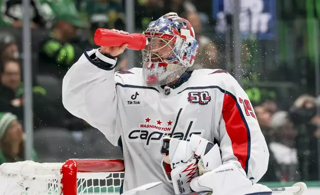 Washington Capitals goaltender Charlie Lindgren sprays himself with water during a timeout during the first period of an NHL hockey game against the Dallas Stars in Dallas, Monday, Dec. 16, 2024. (AP Photo/Gareth Patterson)