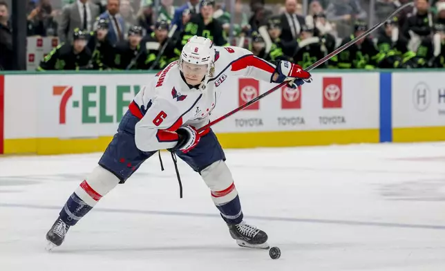 Washington Capitals defenseman Jakob Chychrun lines up a shot during the second period of an NHL hockey game against the Dallas Stars in Dallas, Monday, Dec. 16, 2024. (AP Photo/Gareth Patterson)