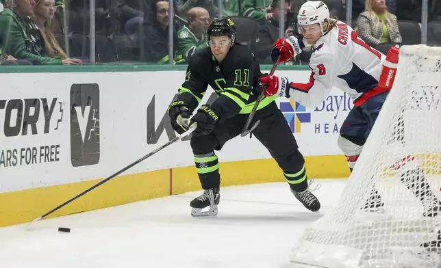 Dallas Stars center Logan Stankoven (11) recovers the puck as Washington Capitals defenseman Jakob Chychrun (6) defends during the first period of an NHL hockey game in Dallas, Monday, Dec. 16, 2024. (AP Photo/Gareth Patterson)