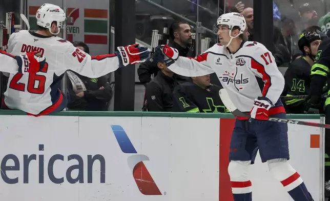 Washington Capitals center Dylan Strome (17) celebrates with center Nic Dowd (26) after scoring during the first period of an NHL hockey game against the Dallas Stars in Dallas, Monday, Dec. 16, 2024. (AP Photo/Gareth Patterson)