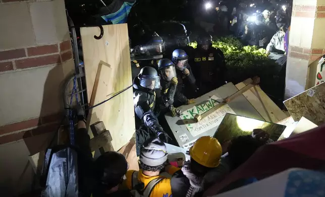 Police break through a barrier set up by pro-Palestinian demonstrators on the UCLA campus Thursday, May 2, 2024, in Los Angeles. (AP Photo/Jae C. Hong)