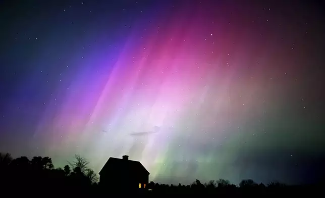 The northern lights flare in the sky over a farmhouse, late Friday, May 10, 2024, in Brunswick, Maine. (AP Photo/Robert F. Bukaty)