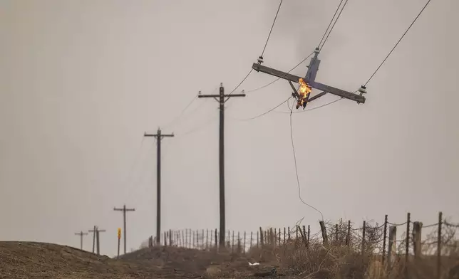 A telephone pole burns from the Smokehouse Creek Fire, Wednesday, Feb. 28, 2024, in Canadian, Texas. (AP Photo/David Erickson)