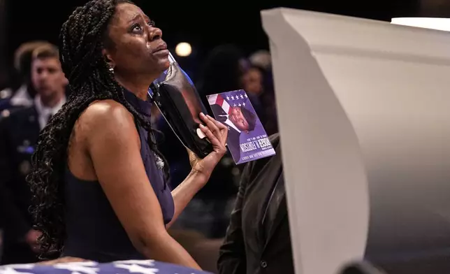 A mourner stands at the casket of slain airman Roger Fortson during his funeral at New Birth Missionary Baptist Church, Friday, May 17, 2024, near Atlanta. (AP Photo/Brynn Anderson)