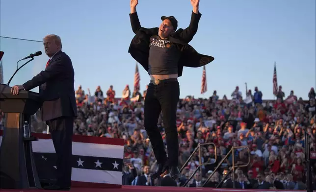 Elon Musk jumps on the stage as Republican presidential nominee former President Donald Trump speaks at a campaign rally at the Butler Farm Show, Saturday, Oct. 5, 2024, in Butler, Pa. (AP Photo/Evan Vucci)