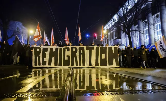 "Remigration" is written on a banner at a demonstration by right-wing groups in Magdeburg, Germany, on Saturday, Dec. 21, 2024, a day after a driver drove into a group of people at the Christmas market in the city. (dpa via AP)