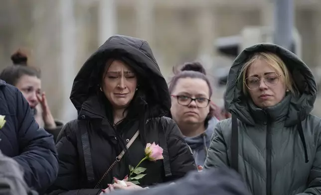 Citizens pay tribute and cry for deaths outside St. John's Church near a Christmas Market, where a car drove into a crowd on Friday evening, in Magdeburg, Germany, Saturday, Dec. 21, 2024. (AP Photo/Ebrahim Noorozi)