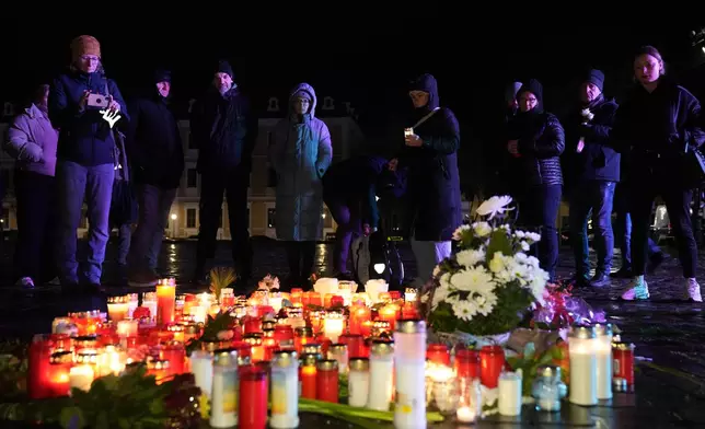 People light candles outside Magdeburg Cathedral after a memorial service for victims of Friday's Christmas Market attack, where a car drove into a crowd, in Magdeburg, Germany, Saturday, Dec. 21, 2024. (AP Photo/Ebrahim Noroozi)