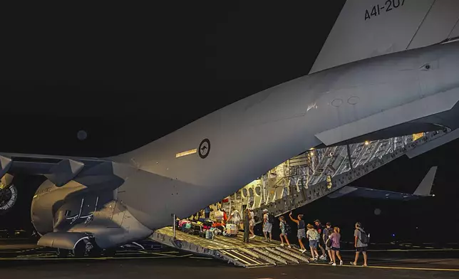 In this photo released by Australian Department of Defence, Australian citizens board a Royal Australian Air Force aircraft for a flight home from Bauerfield International Airport, Port Vila, Vanuatu, Wednesday, Dec. 18, 2024 following a powerful earthquake that struck just off the coast of Vanuatu in the South Pacific Ocean. (CPL Adam Abela/Australian Department of Defence via AP)