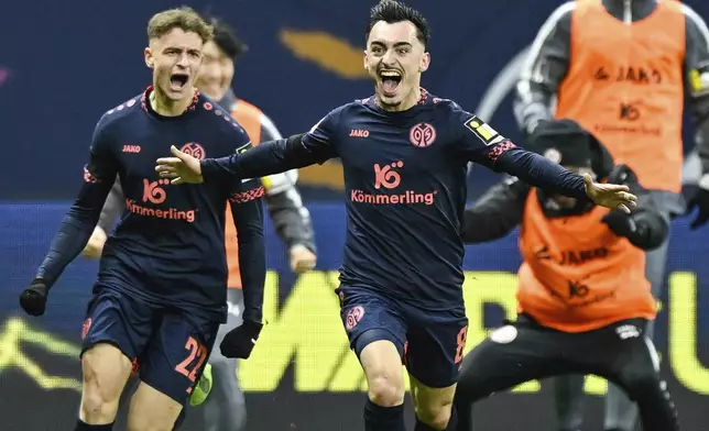 Mainz' Paul Nebel, front, celebrates after scoring his side's third goal during the German Bundesliga soccer match between Eintracht Frankfurt and FSV Mainz 05 in Frankfurt, Germany, Saturday, Dec. 21, 2024. (Uwe Anspach/dpa via AP)