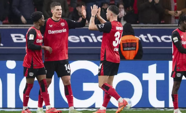 Leverkusen's Patrik Schick, second left, celebrates after scoring the opening goal during the German Bundesliga soccer match between Bayer 04 Leverkusen and SC Freiburg in Leverkusen, Germany, Saturday, Dec. 21, 2024. (Marius Becker/dpa via AP)