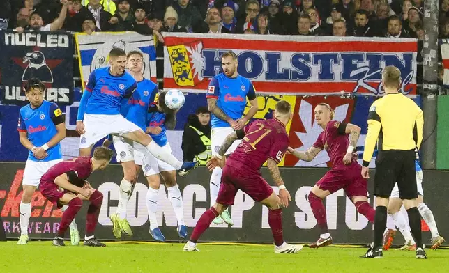 The Kiel defense blocks a free kick from Augsburg's Phillip Tietz, third from right, during the Bundesliga soccer between Holstein Kiel and FC Augsburg in Kiel, Germany, Saturday, Dec. 21, 2024. (Frank Molter /dpa via AP)