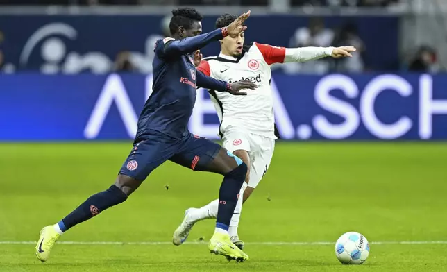 Mainz' Danny da Costa, left, and Frankfurt's Farees Chaibi, right challenge for the ball during the German Bundesliga soccer match between Eintracht Frankfurt and FSV Mainz 05 in Frankfurt, Germany, Saturday, Dec. 21, 2024. (Uwe Anspach/dpa via AP)