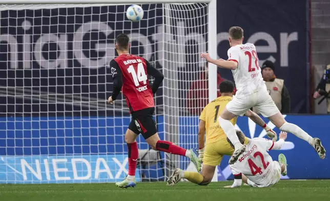 Leverkusen's Patrik Schick, left, scores the opening goal during the German Bundesliga soccer match between Bayer 04 Leverkusen and SC Freiburg in Leverkusen, Germany, Saturday, Dec. 21, 2024. (Marius Becker/dpa via AP)