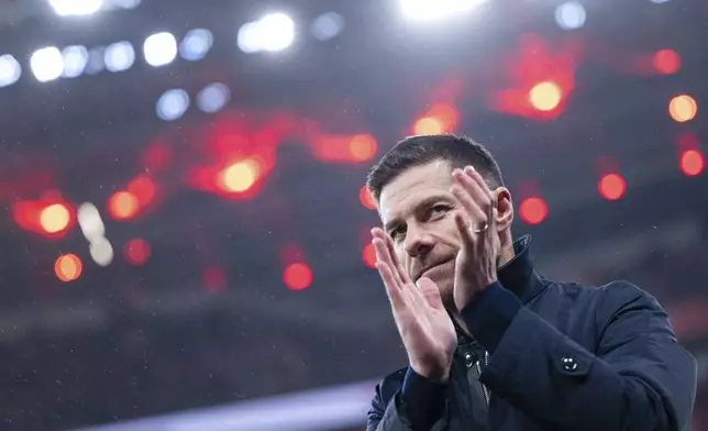 Leverkusen's head coach Xabi Alonso applauds before the German Bundesliga soccer match between Bayer 04 Leverkusen and SC Freiburg in Leverkusen, Germany, Saturday, Dec. 21, 2024. (Marius Becker/dpa via AP)