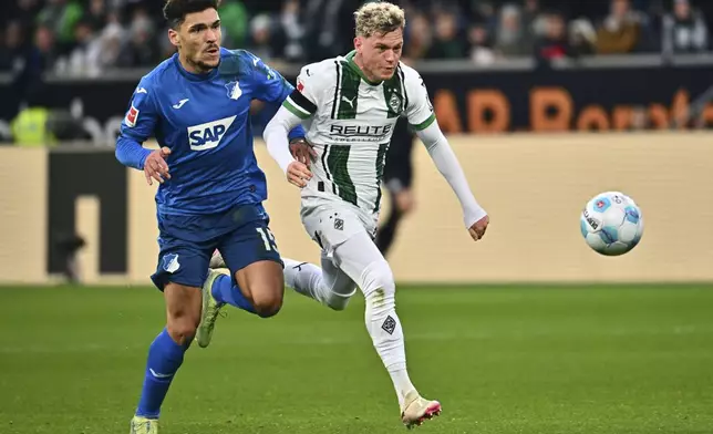 Hoffenheim'sValentin Gendrey, left, and Moenchengladbach's Robin Hack, right, challenge for the ball during the German Bundesliga soccer match between TSG 1899 Hoffenheim and Borussia Moenchengladbach in Sinsheim, Germany, Saturday, Dec. 21, 2024. (Jan-Philipp Strobel/dpa via AP)