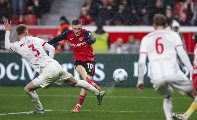 Leverkusen's Florian Wirtz, center, scores his side's second goal during the German Bundesliga soccer match between Bayer 04 Leverkusen and SC Freiburg in Leverkusen, Germany, Saturday, Dec. 21, 2024. (Marius Becker/dpa via AP)